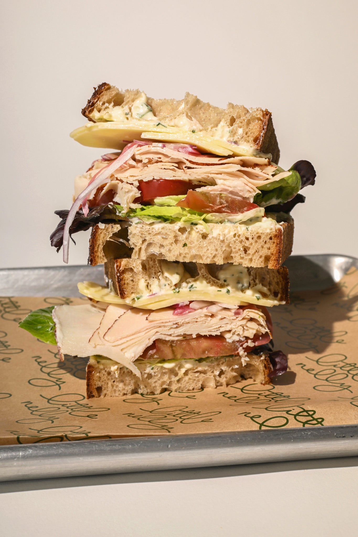 Stack of sandwiches on a tray with a light background